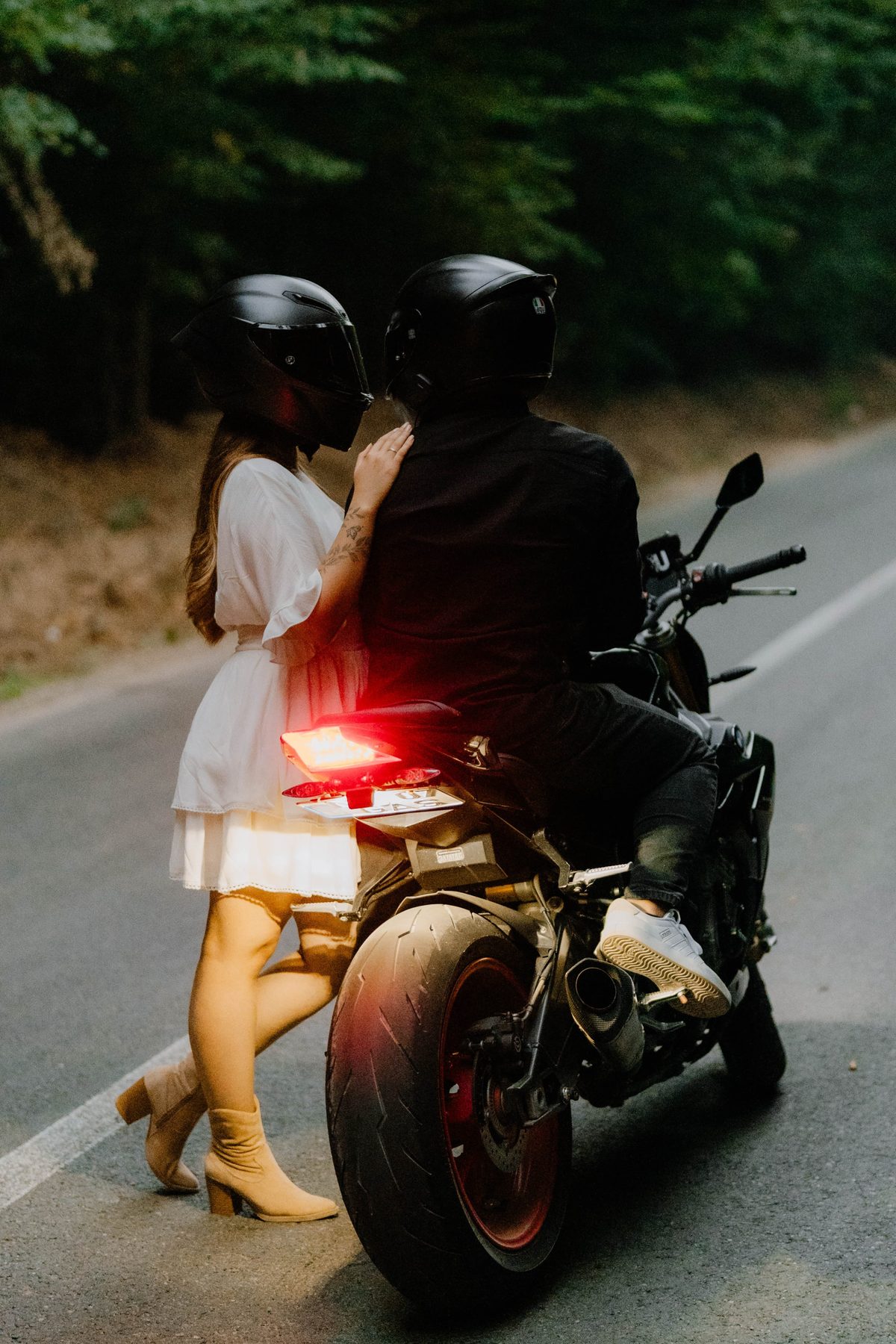 Cuplu lângă motocicletă pe șosea